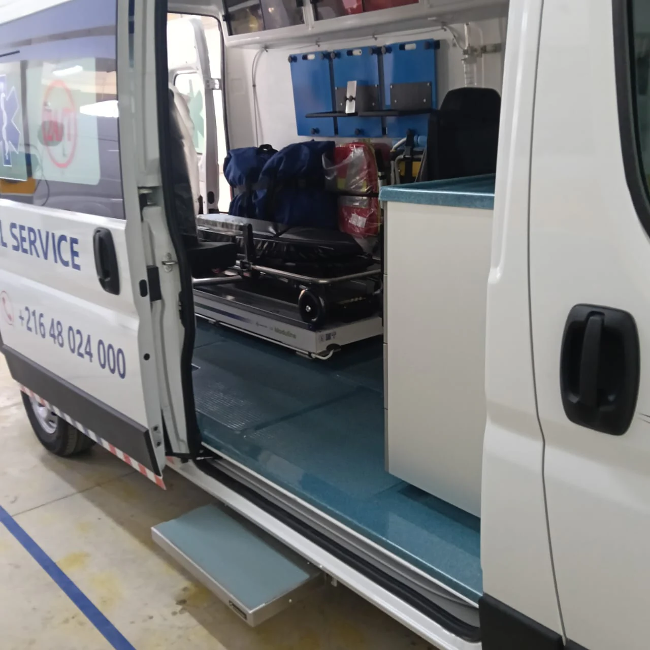 Open side door of an EMS ambulance looking into the patient compartment