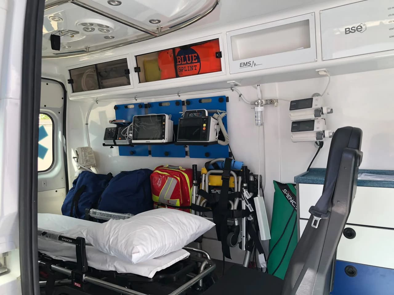 EMS medicalised ambulance compartment: stretcher, monitor and wall-mounted equipment