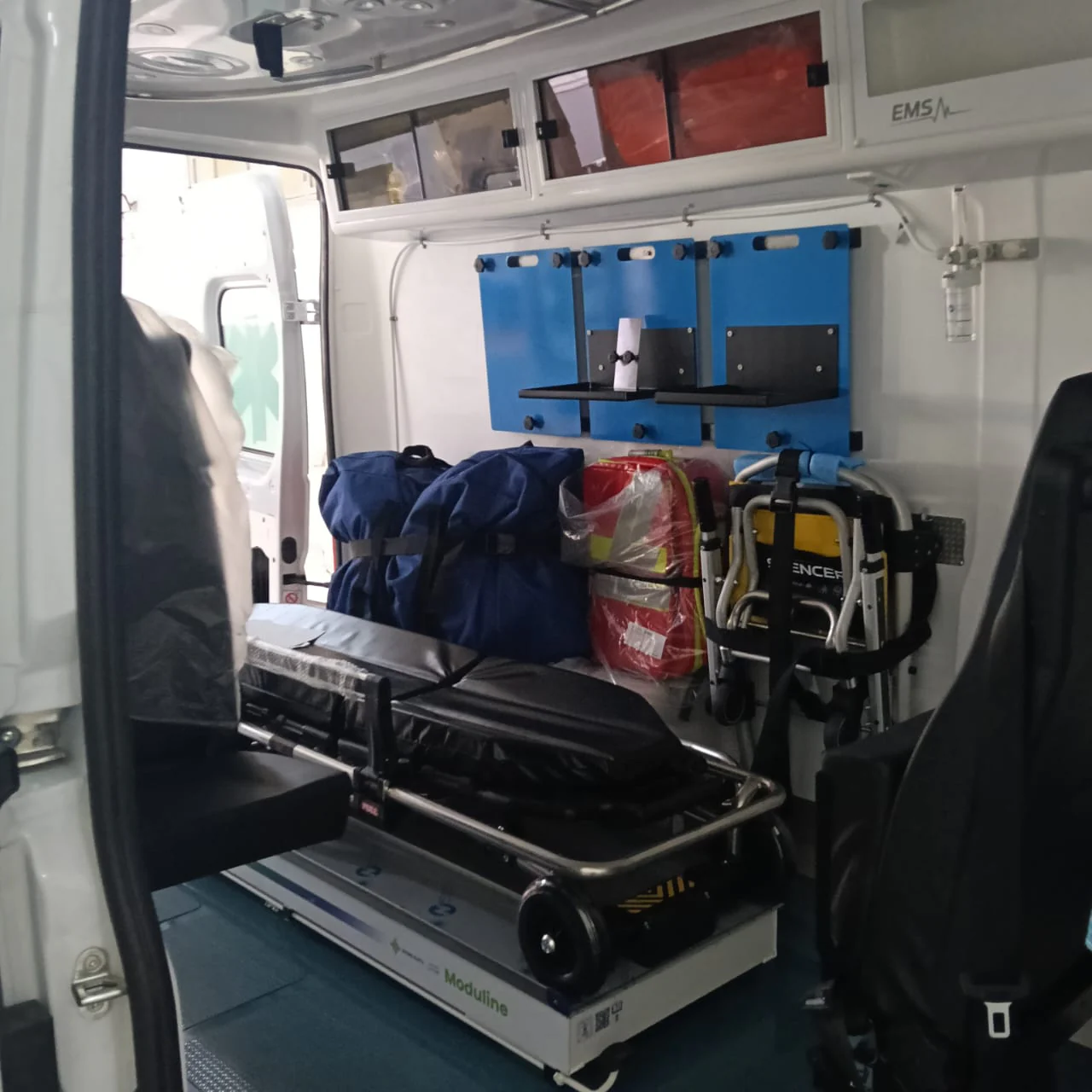 Stretcher and emergency bags stowed inside an EMS ambulance compartment