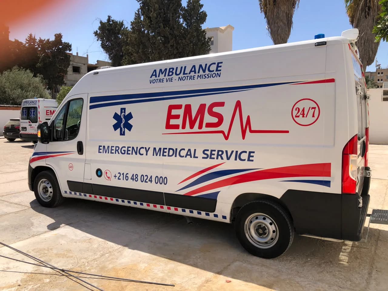 سيارة إسعاف EMS بيجو بوكسر من الجانب مع علامة 24/7 ورقم الهاتف